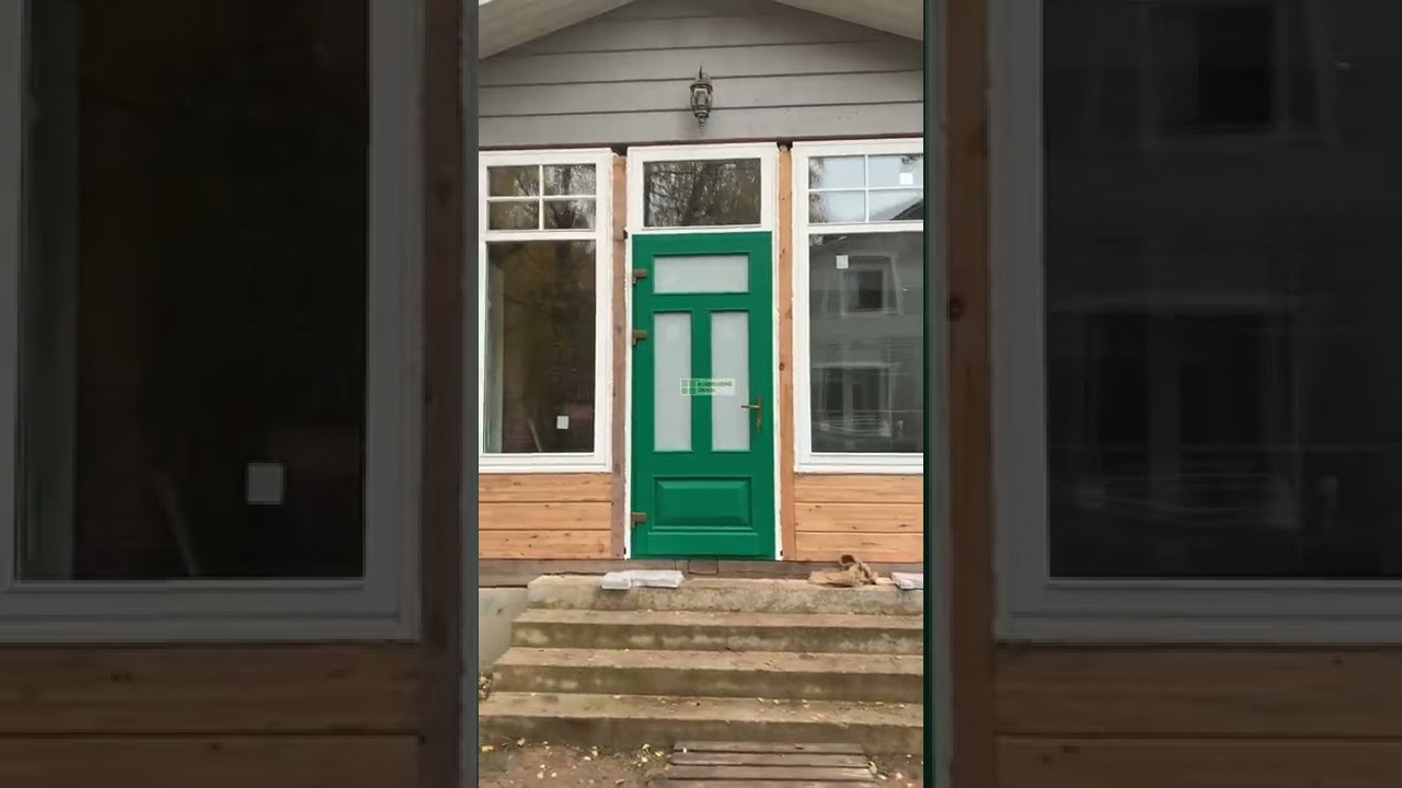 Яркая зеленая дверь и белые окна, и все это из дерева